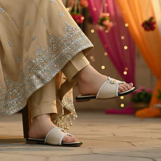 Close-up of feet wearing women slippers with a traditional outfit in a festive setting.
